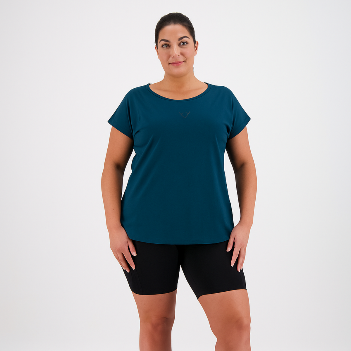 Woman wearing a teal t-shirt and black shorts on a white background
