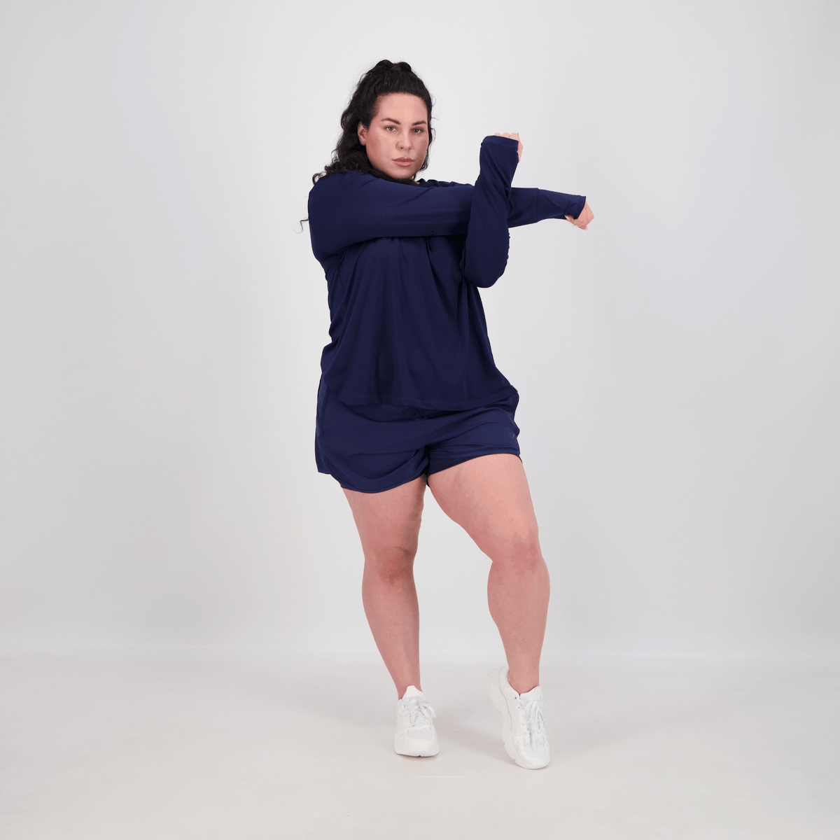curvy woman doing stretching and wearing long sleeve tee