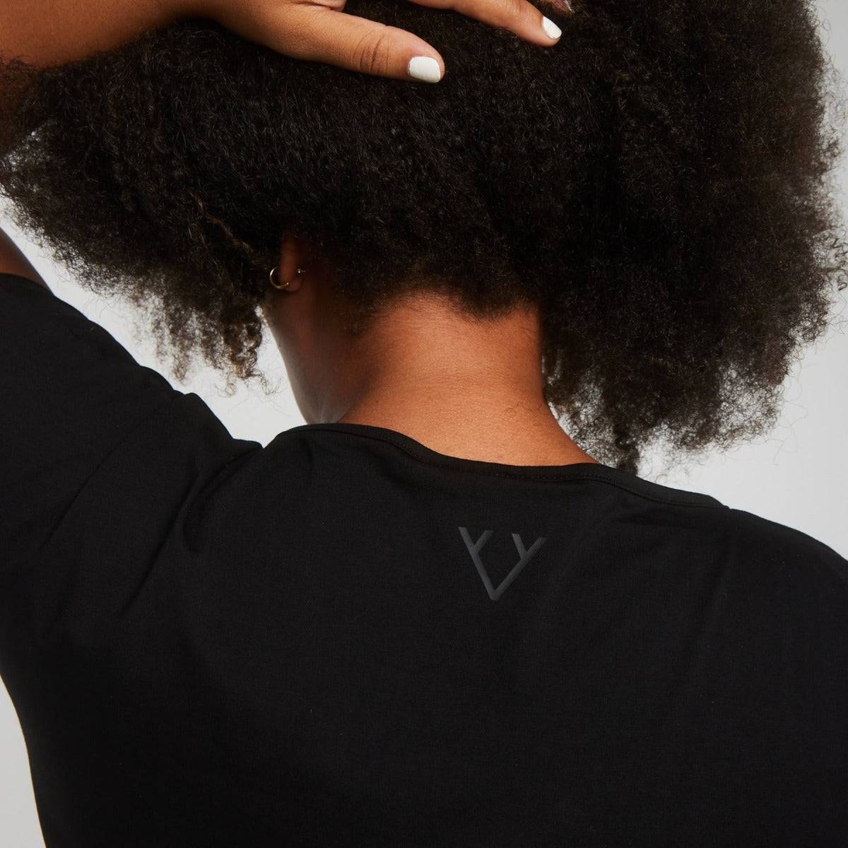 Woman wearing Victoria Stag's Core Cap Sleeved Tee in Black V2 back logo