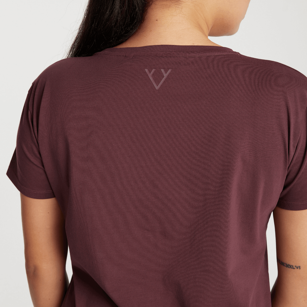Woman wearing Victoria Stag's Core Trainer Tee in Ox Blood back logo